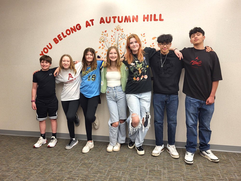Kids under "You Belong at Autumn Hill" sign